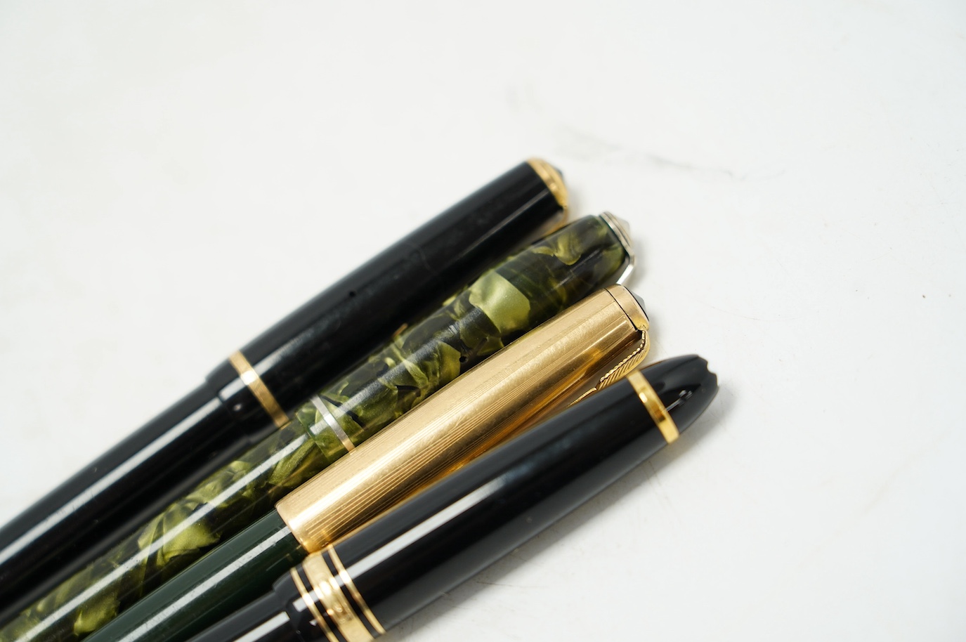 A Montblanc fountain pen with 14k gold nib and three others comprising two Parker’s and a marbleised example